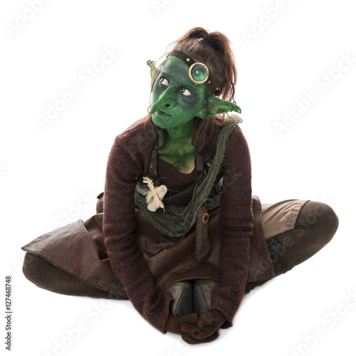 Fotografi weiblicher kleiner goblin sitzt und schaut zur Seite, freistelle