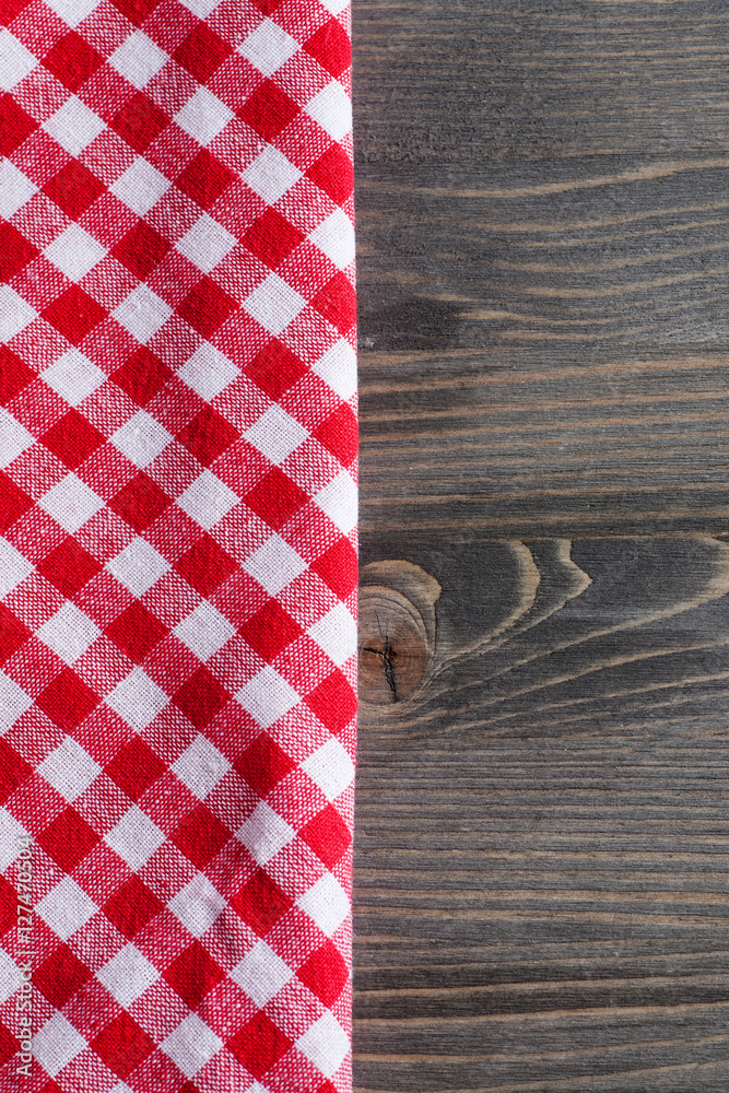 Obraz premium Red checkered napkin on gray wooden table