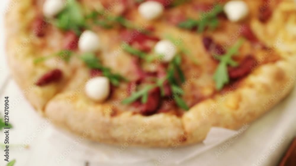 Thick-crust pizza with hunting sausages, mozzarella cheese on a white wooden background