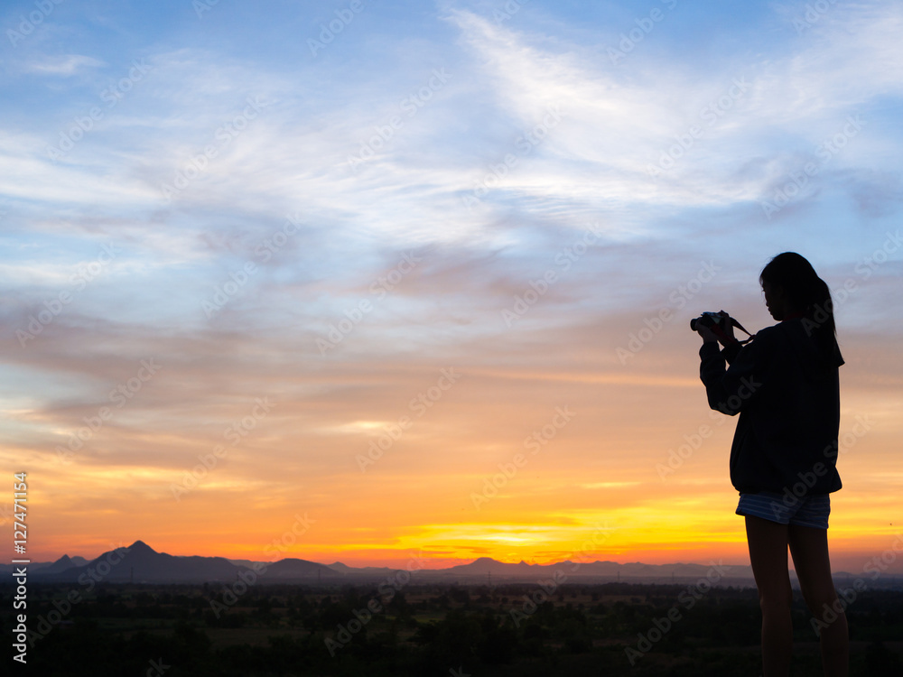 Silhouette of woman shooting with camera at sunset Silhouette of woman shooting with camera at sunset
