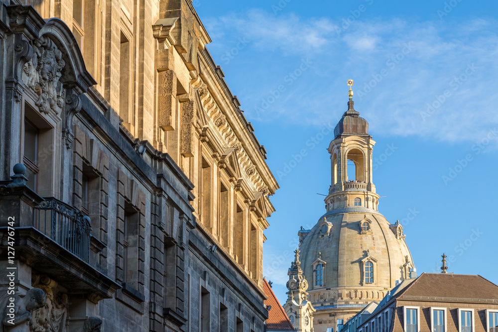 City center of Dresden, Germany, with historic buildings and the Fuerstenzug (Procession of Princes), a giant mural, with famous Frauenkirche in the background.