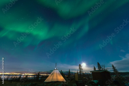 Traditional Sami reindeer-skin tents (lappish yurts) in Troms region of Norway .The polar lights in Norway . © belov3097