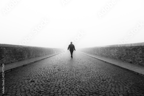 Persona cammina da sola nella nebbia photo