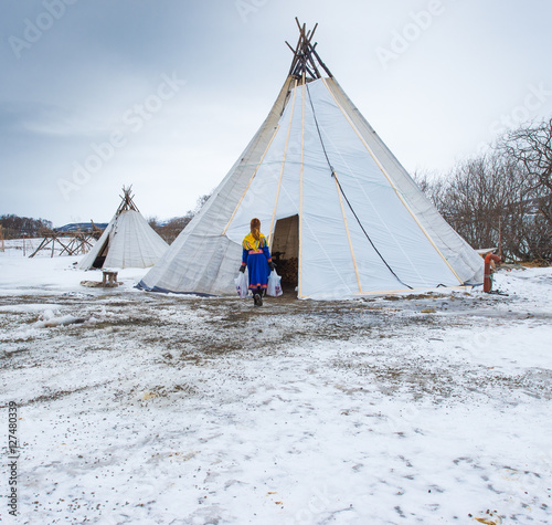 Reindeer breeder dressed in national Same clothes with a reinde photo