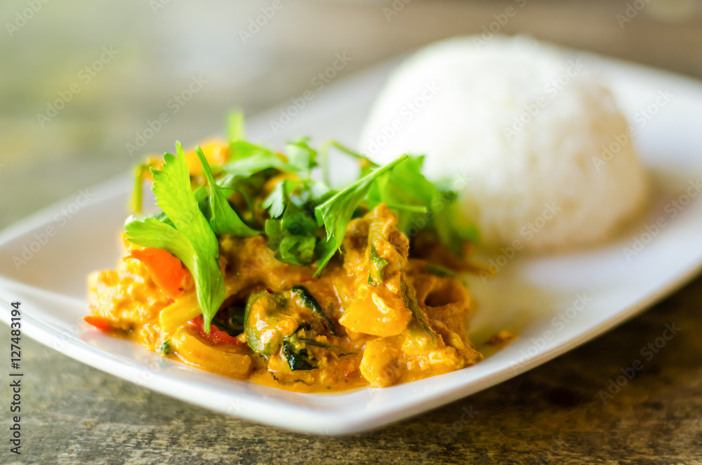 Thai food,Stir fried squid with yellow curry and cooked rice on white dish Thai food,Stir fried squid with yellow curry and cooked rice on white dish