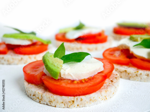 Healthy food - sandwiches, rice crackers with tomato, avocado and mozzarella cheese