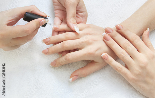 manicure making - female hands  covering of transparent enamel