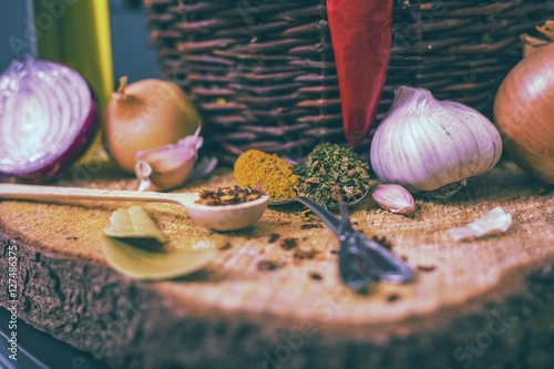 assorted spices on wooden background, obion, garlic, pepper, curry photo