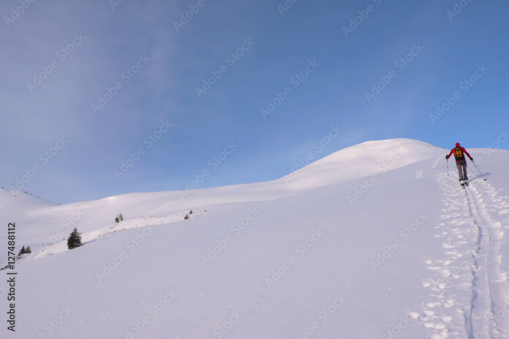 backcountry skier climbing a mountain in the Swiss Alps for an off-piste descent