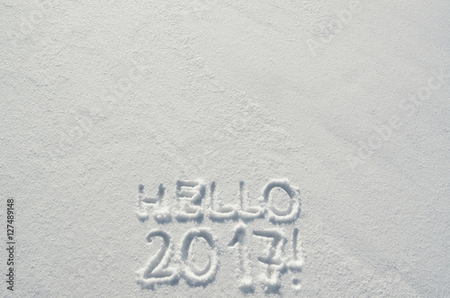 Hello 2017 text letters handwritten on flat snow surface. Empty space for copy, lettering. New year holiday postcard, greeting card template.