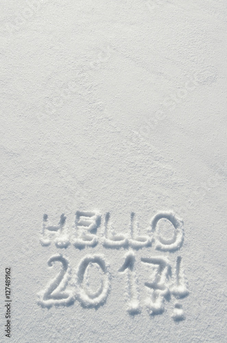 Hello 2017 text letters handwritten on flat snow surface. Empty space for copy, lettering. New year holiday postcard, greeting card template.