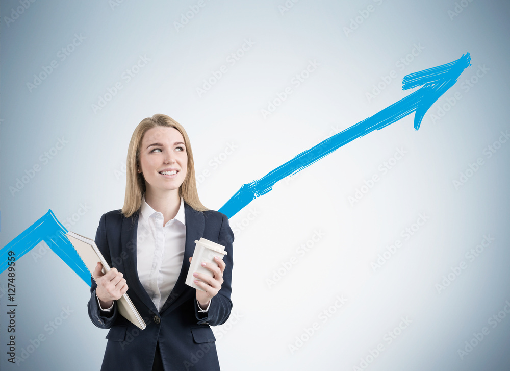 Blond woman with coffee and notebook near gray wall with a graph Blond woman with coffee and notebook near gray wall with a graph