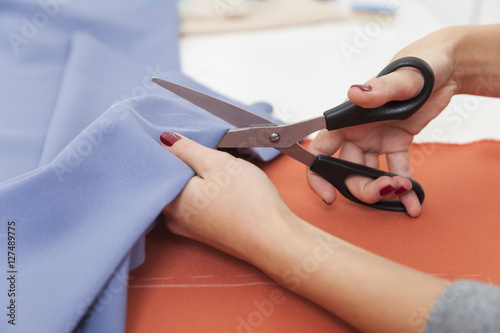 Close up of a woman cutting a blue piece of tissue