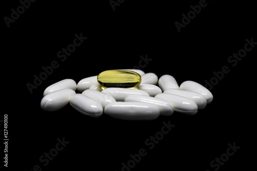 Closeup group of medicines and vitamin tablets on black background.