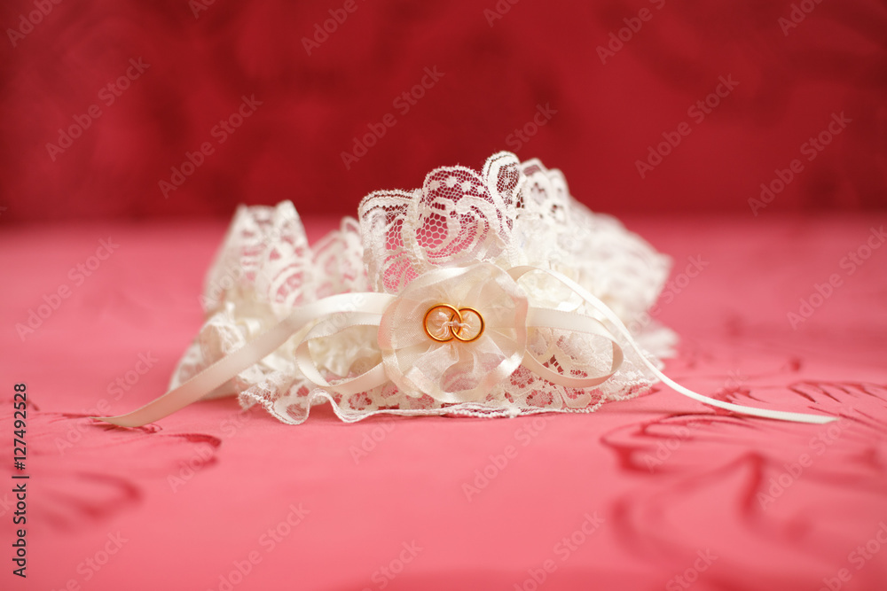 Decorated wedding garter, red background. Marriage concept Decorated wedding garter, red background. Marriage concept