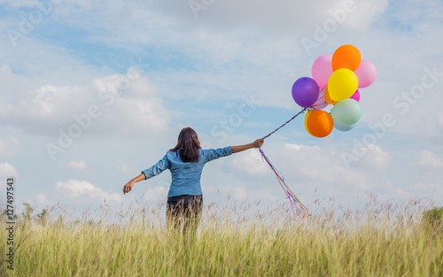 Beautiful Girl jumping with balloons on the beach