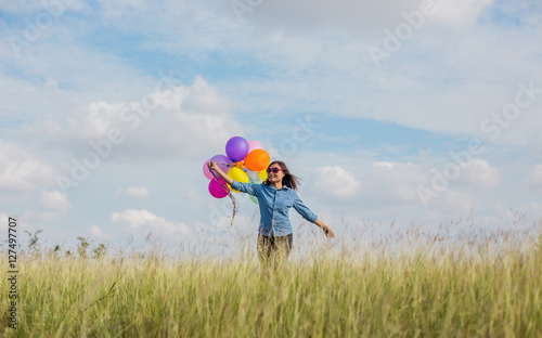 Beautiful Girl jumping with balloons on the beach