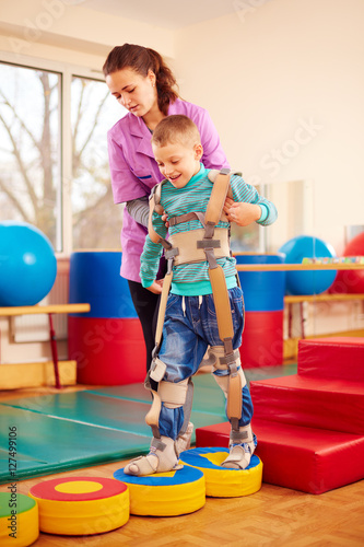 Wallpaper Mural cute kid having physical musculoskeletal therapy in rehabilitation center Torontodigital.ca