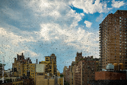 Photography View of New York cityscape through a rainy window.