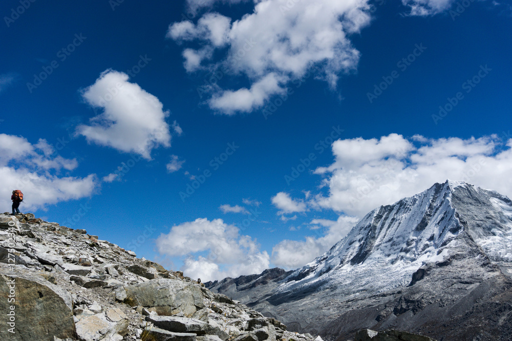 a hiker on a ridge in front of Ranrapalca mountain in the Cordillera Blanca in the Andes in Peru