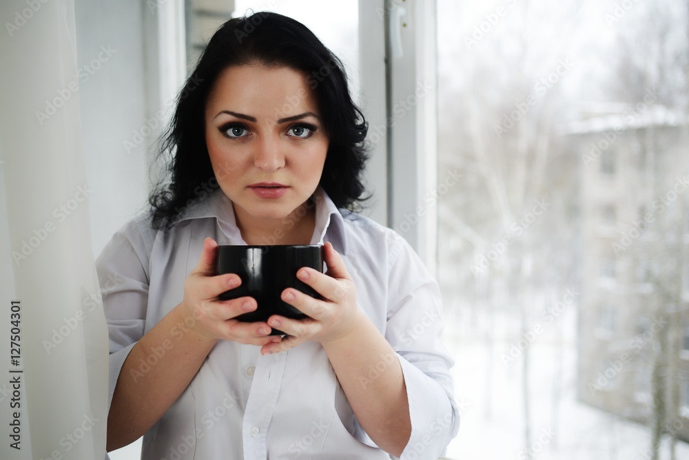 Portrait of young woman holding a cup of coffee. Portrait of young woman holding a cup of coffee.
