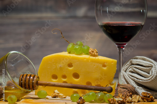 cheese plate for wine includes cheese, grapes , honey and nuts