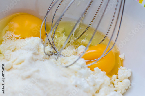 Mix ingredients for dough cheese pie. Semolina, two eggs, sour creme, flour, solt and sugar photo