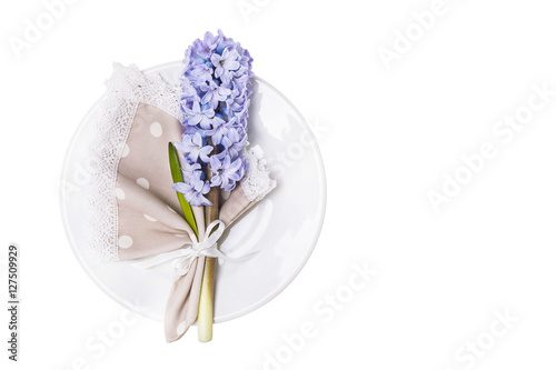 Linen napkin with blue hyacinth on a plate isolated on white