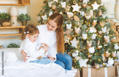 happy family mother and child daughter on Christmas morning tre