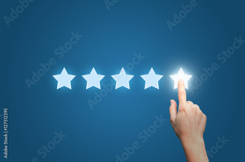 Businesswoman pointing five star to increase photo
