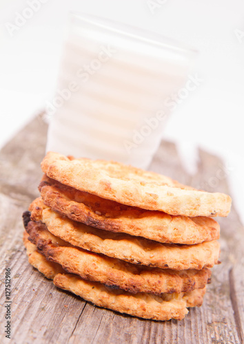 Cookies and a glass of milk on wooden background