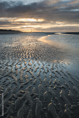 Beautiful beach coastal low tide landscape image at sunrise with