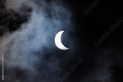 Partial solar eclipse through clouds