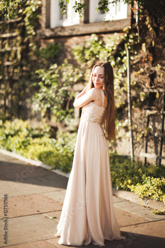 Attractive young woman with long dress enjoying her time outside in park sunset background © olegparylyak
