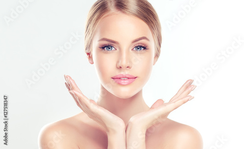 Beautiful Young Woman with clean fresh skin  . Facial  treatment   . Cosmetology , beauty  and spa .
 photo