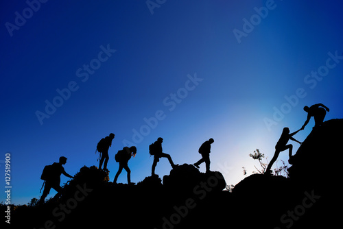 People walking in the mountain and helping hand