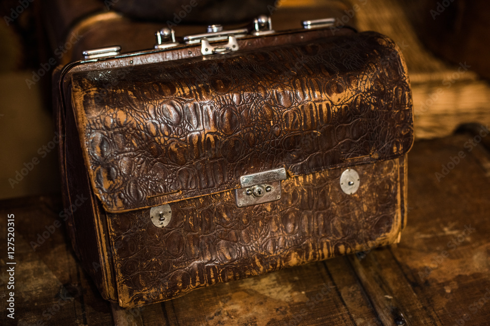 Vintage brown leather valise with metal parts on a wooden table Stock Photo  | Adobe Stock