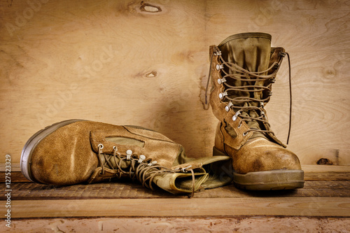 old brown military boots on a wooden table