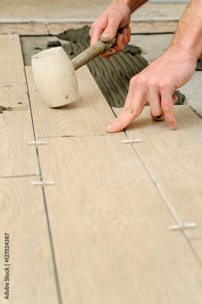 Worker putting tiles on the floor. Worker putting tiles on the floor.