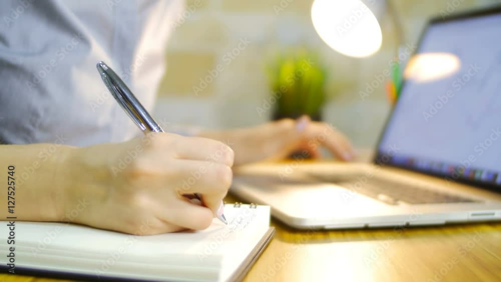 The young girl does notes in a notebook