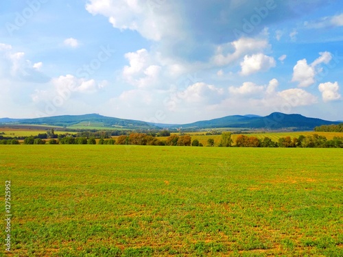 Field and mountains landscape during sunny day