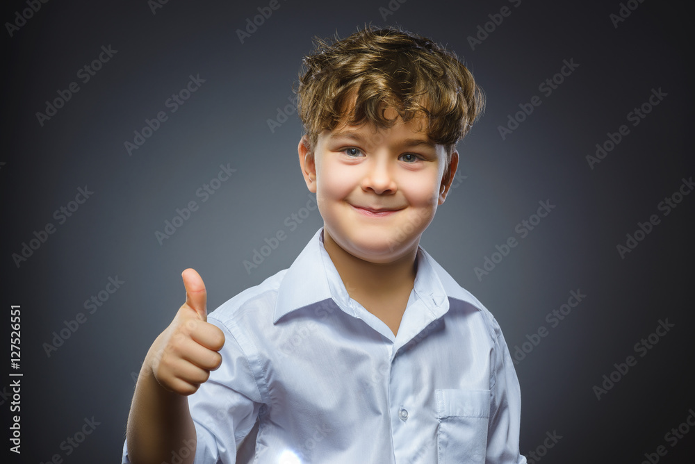 Closeup portrait successful happy boy show thumb up isolated grey background. Positive human emotion. Closeup portrait successful happy boy show thumb up isolated grey background. Positive human emotion.