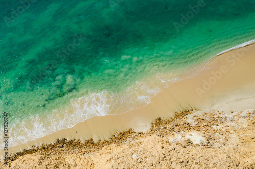Stark contrast of beautiful turquoise blue ocean meeting yellow beach photo