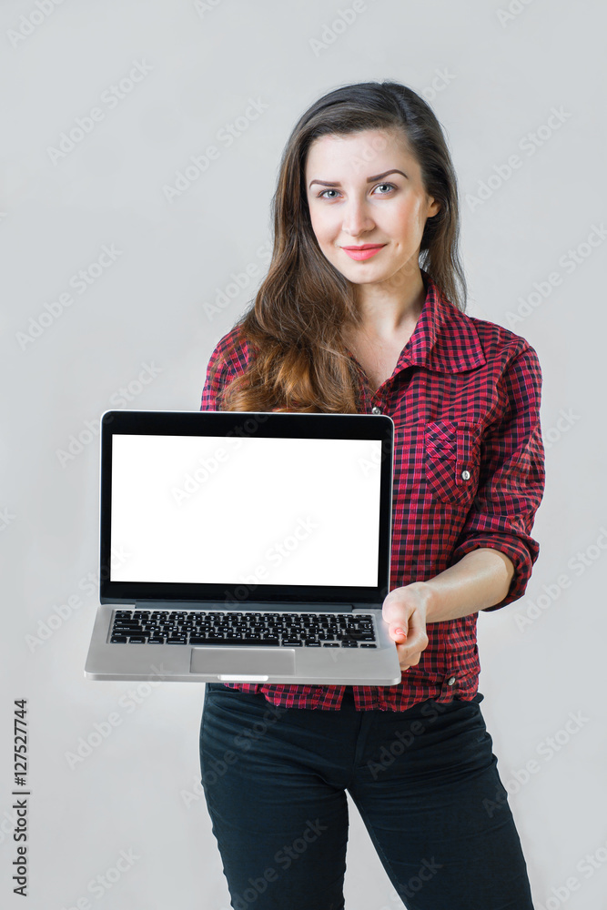 young girl holding a silver laptop and looking at the camera young girl holding a silver laptop and looking at the camera