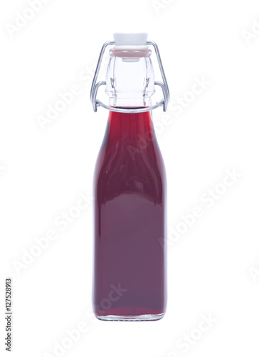 Homemade raspberry liqueur in clear glass bottle with swing top isolated on white background