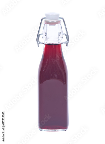 Homemade raspberry liqueur in clear glass bottle with swing top isolated on white background