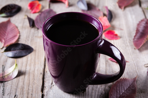 Cuadro en lienzo Cup of coffee surounded by red and purple fall leaves