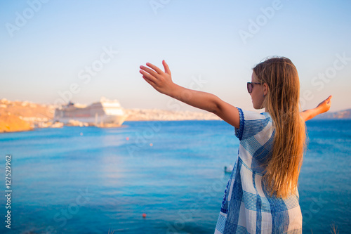 Adorable little girl at beach background big lainer in Greece
