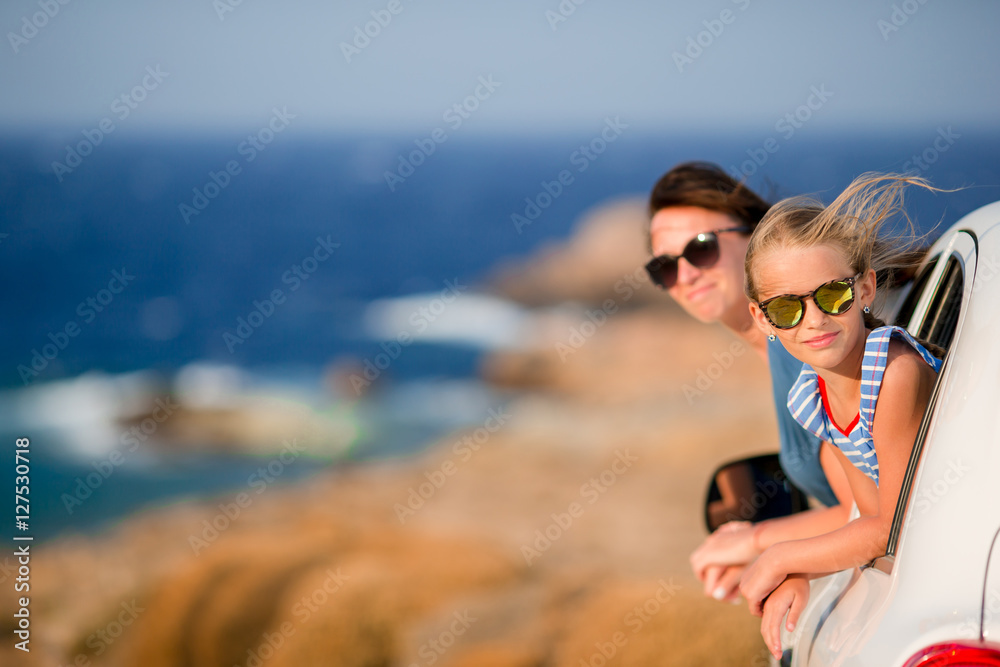 Mother and daughter on vacation travel by car. Summer holiday and car travel concept. Family travel.
