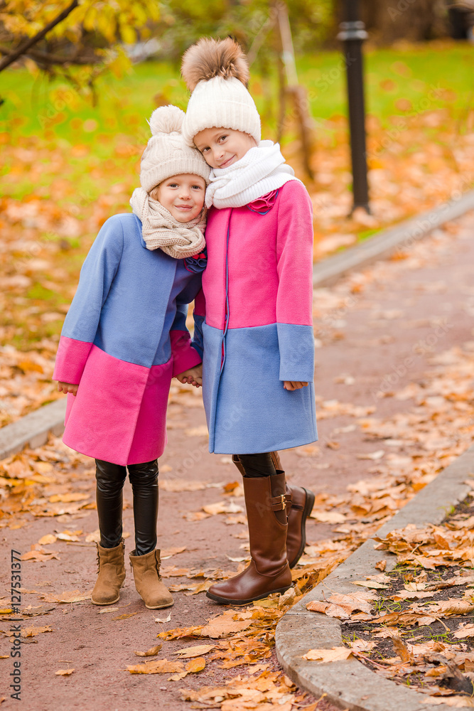 Fototapeta premium Little adorable girls outdoors at warm sunny autumn day